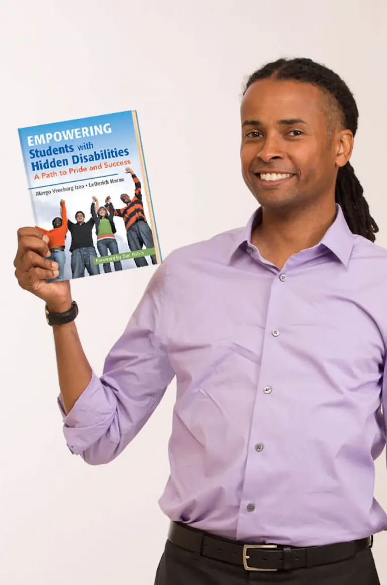 LeDerick holding his book 'Empowering Students with Hidden Disabilities'